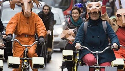 Sonic bike performance - group of cyclists with speakers and masks